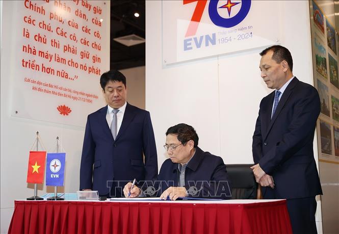 Thủ tướng Phạm Minh Chính viết lưu bút tại phòng truyền thống của ngành Điện. Ảnh: Dương Giang-TTXVN
