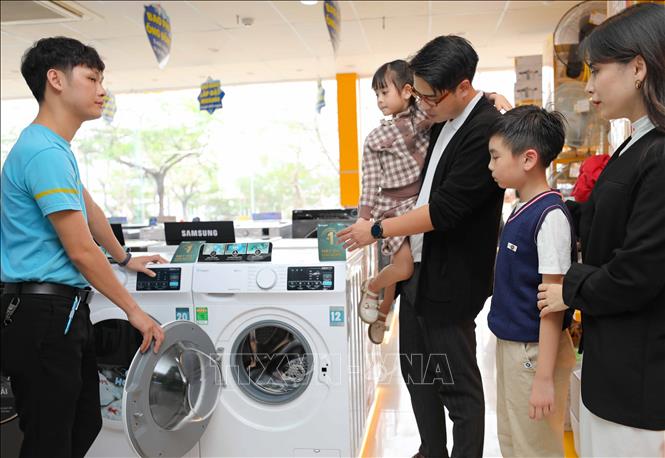 Người tiêu dùng tìm hiểu về sản phẩm máy giặt Casper đang có chương trình giảm giá sâu. Ảnh: Thanh Tùng - TTXVN 