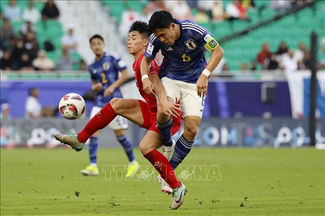 Pha tranh bóng quyết liệt giữa Đình Bắc và Wataru Endo. Ảnh: AFP/TTXVN