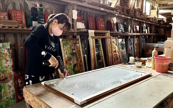 Đóng khung tranh kính để giao hàng cho khách. Ảnh: Thanh Sang - TTXVN