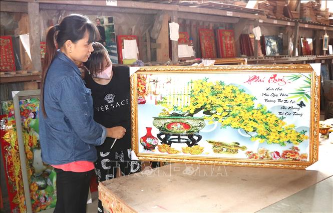 Bức tranh kính mai vàng Phú Quý vừa được lên khung. Ảnh: Thanh Sang – TTXVN