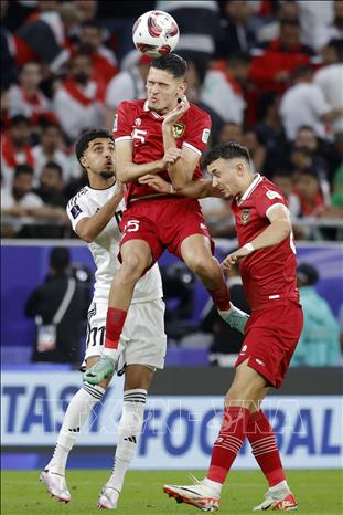 Pha tranh bóng bổng giữa cầu thủ hai đội. Ảnh: AFP/TTXVN
