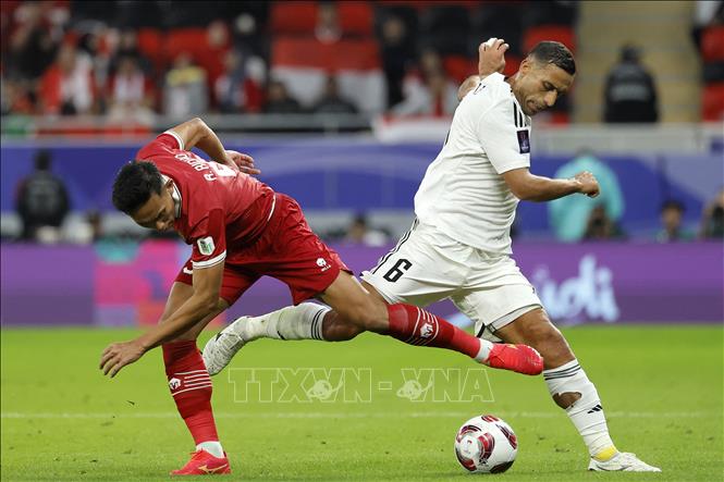 Pha tranh bóng giữa hậu vệ Iraq Ali Adnan (phải) và hậu vệ Indonesia Rizky Ridho. Ảnh: AFP/TTXVN