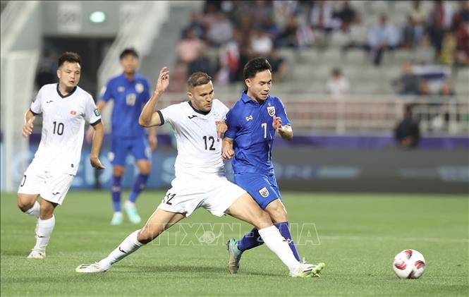 Tiền vệ Supachok (phải) bị Abdurakhmanov (trái) phá bóng trong chân. Ảnh: Hoàng Linh - PV TTXVN từ Qatar