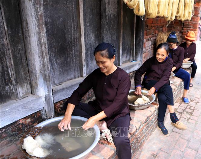 Kén tằm sau khi luộc sẽ được ngâm nước lạnh rồi kéo thành từng sợi. Ảnh: Thế Duyệt – TTXVN 