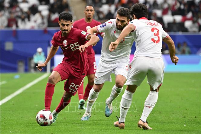 Tiền đạo Qatar Ahmed al-Ganehi (số 25) đi bóng qua hậu vệ Tajikistan Tabrezi Davlatmir (số 3) trong trận đấu. Ảnh: AFP/TTXVN