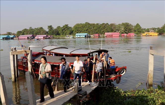 Du khách đi thuyền tham quan làng bè đa sắc màu. Ảnh: Thanh Sang - TTXVN.