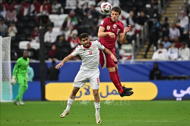 Pha tranh bóng bổng giữa tiền vệ Qatar Lucas Mendes (phải) với tiền đạo Tajikistan Rustam Soirov trong trận đấu. Ảnh: AFP/TTXVN