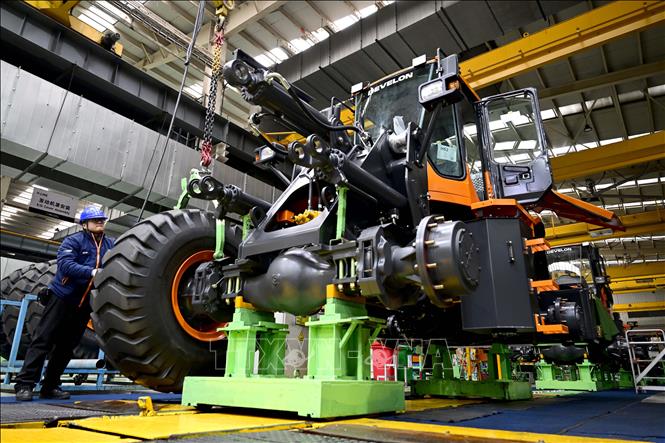 Công nhân làm việc trên dây chuyền sản xuất máy kéo Develon ở Yên Đài, tỉnh Sơn Đông (Trung Quốc) ngày 17/1/2024. Ảnh: THX/TTXVN