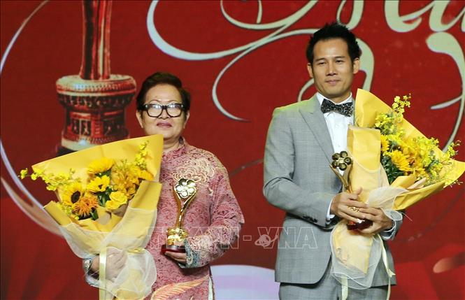 Đạo diễn Hoa Hạ cùng diễn viên Thanh Thức nhận giải Vở diễn sân khấu-truyền hình được yêu thích nhất và Bộ phim điện ảnh được yêu thích nhất. Ảnh: Thu Hương - TTXVN
