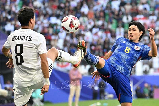 Tiền vệ Ibrahim Bayesh (trái) của Iraq tranh bóng với tiền vệ Takumi Minamino của Nhật Bản. Ảnh: AFP/TTXVN
