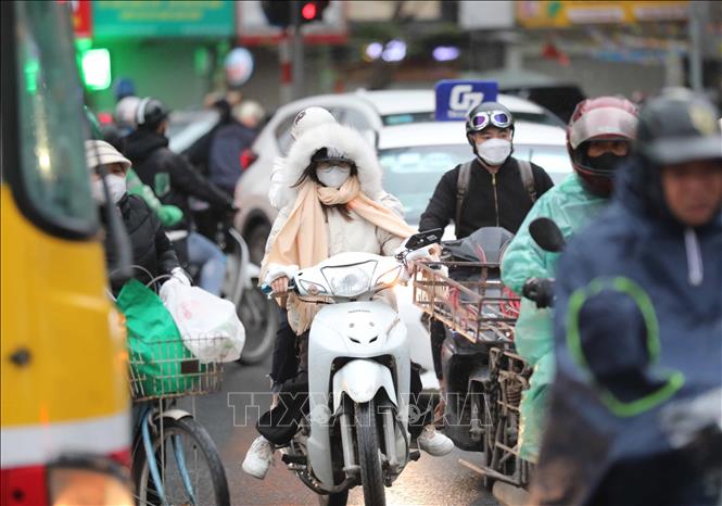 Người dân Hà Nội di chuyển trong mưa, rét. Ảnh: Thanh Tùng - TTXVN

