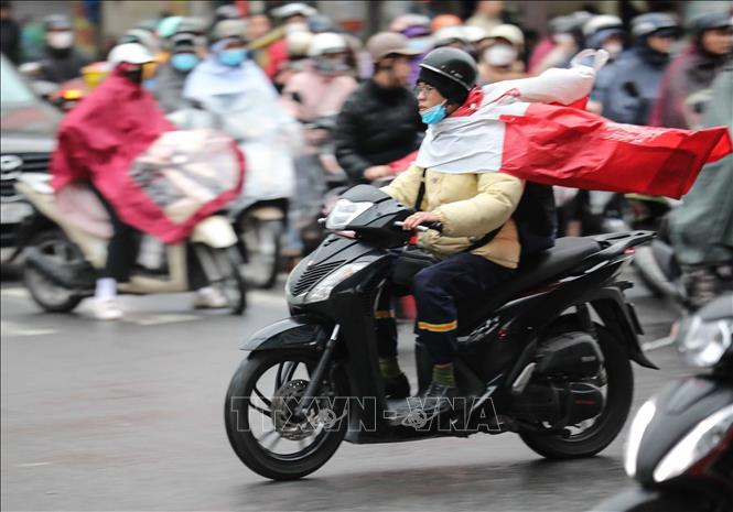 Người dân Hà Nội di chuyển trong mưa, rét. Ảnh: Thanh Tùng - TTXVN
