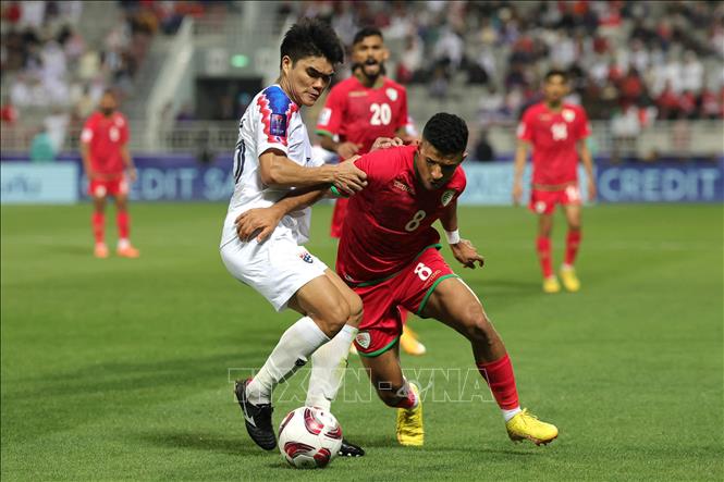 Pha tranh bóng giữa tiền vệ Thái Lan Peeradon Chamratsamee (trái) và tiền vệ Oman Zahir al-Aghbari. Ảnh: AFP/TTXVN