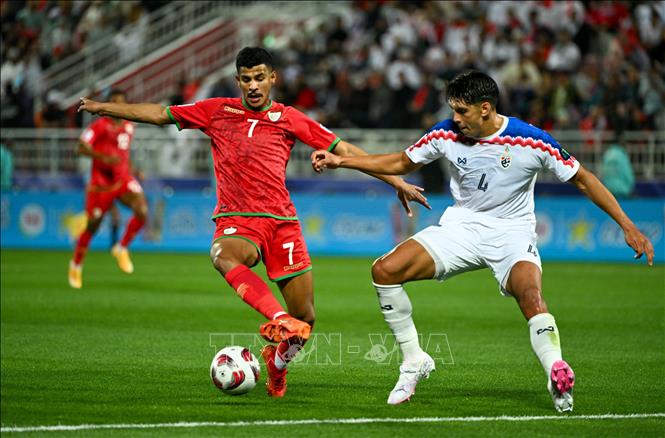 Pha tranh bóng giữa cầu thủ Elias Dolah (phải) tuyển Thái Lan và Issam Abdallah Alsabhi tuyển Oman. Ảnh: THX/TTXVN