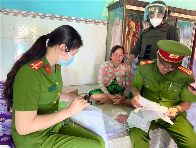 Cơ quan điều tra thu thập tài liệu, chứng cứ liên quan đến vụ án tại nơi ở của đối tượng Châu Thị Tròn. Ảnh: TTXVN phát 