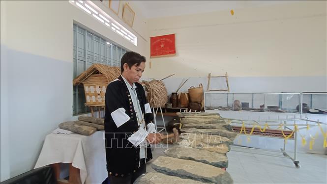 Ông Bo Bo Hùng- cán bộ Trung tâm Văn hóa Thông tin và Thể thao huyện Khánh Sơn giói thiệu đàn đá. Ảnh Đặng Tuấn -TTXVN 