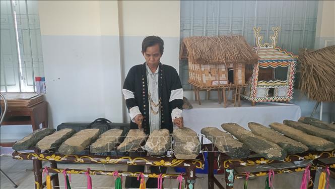 Ông Bo Bo Hùng- cán bộ Trung tâm Văn hóa Thông tin và Thể thao huyện Khánh Sơn giói thiệu đàn đá. Ảnh Đặng Tuấn -TTXVN

