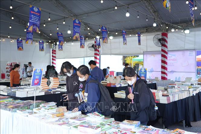 Học sinh lựa chọn các đầu sách được giảm giá tại Chương trình Trạm sách hạnh phúc, tổ chức tại thành phố tỉnh Tây Ninh. Ảnh: Minh Phú - TTXVN 