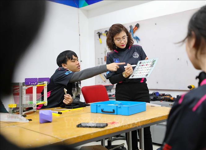 Dưới sự hướng dẫn của cô giáo phụ trách đội Phạm Vũ Bích Hằng, các thành viên đội tuyển từ xuất phát điểm không biết gì về robot đã học tập, nghiên cứu để thiết kế, lắp ráp robot, hoàn thiện hồ sơ kĩ thuật, tập luyện kĩ năng và chiến thuật thi đấu. Ảnh: Thanh Tùng -  TTXVN