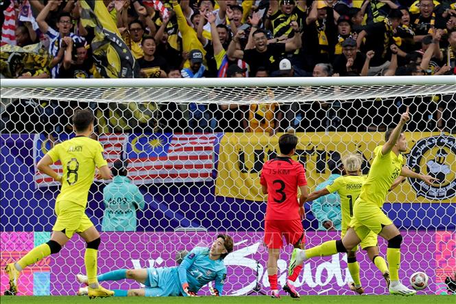 Tiền đạo Malaysia Romel Morales (phải) ăn mừng sau khi ghi bàn thắng ấn định tỉ số 3-3 ở những phút cuối cùng của trận đấu. Ảnh: AFP/TTXVN