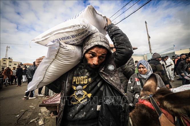 Người tị nạn Palestine nhận lương thực cứu trợ từ Cơ quan cứu trợ của LHQ dành cho người tị nạn Palestine (UNRWA) ở Dải Gaza, ngày 28/1/2024. Ảnh: AFP/TTXVN