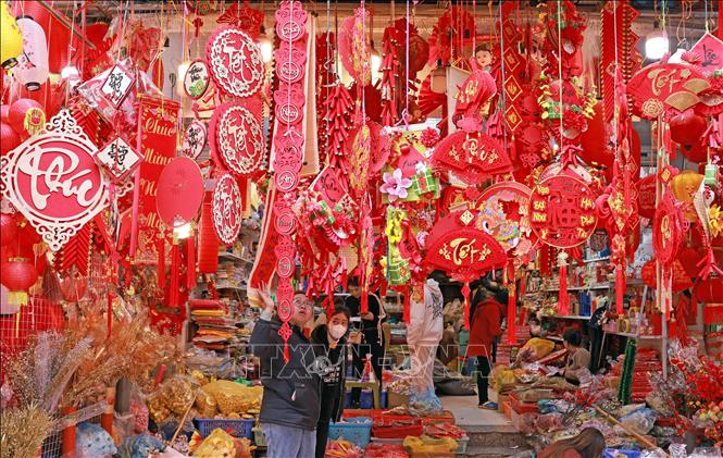 Khách lựa chọn, mua sắm đồ trang trí Tết tại phố Hàng Mã. Ảnh: Trần Việt - TTXVN