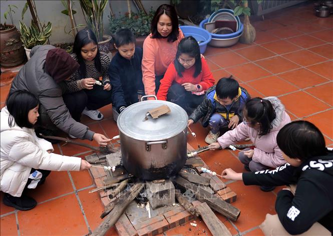 Trông nồi bánh chưng là thú vui của trẻ nhỏ mỗi lần Tết đến. Ảnh: Nhật Anh - TTXVN