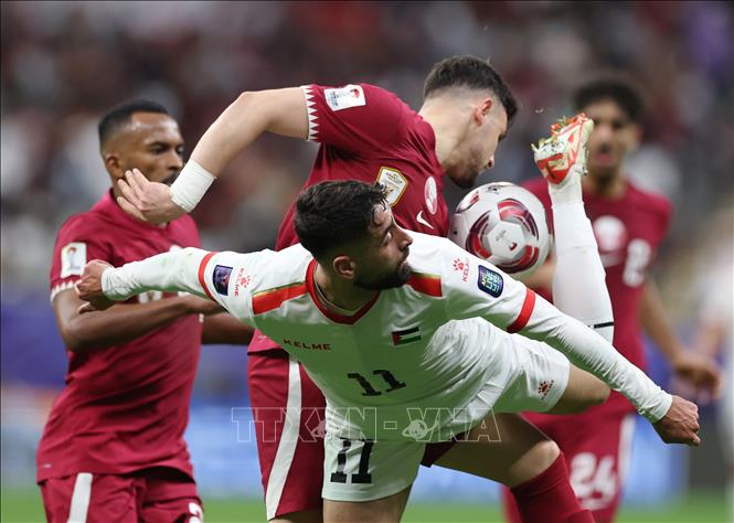 Pha tranh bóng giữa tiền đạo Palestine Oday Dabbagh (số 11) với các tuyển thủ Qatar. Ảnh: THX/TTXVN
