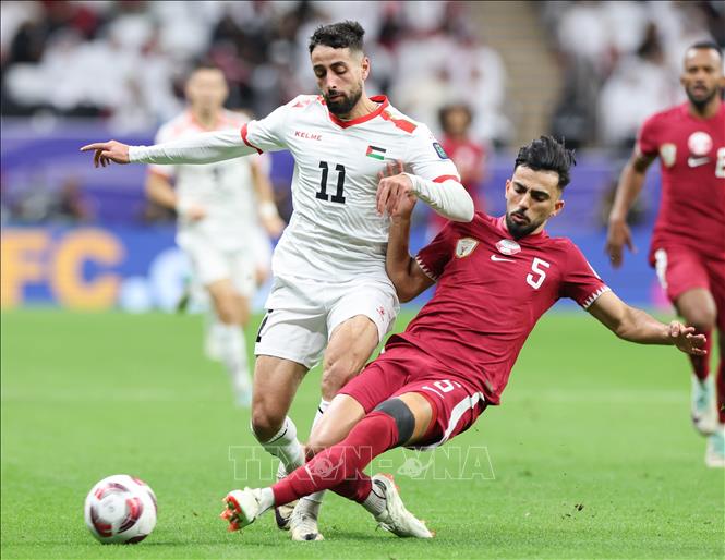 Tiền đạo Qatar Tarek Salman (phải) tranh bóng với đối thủ Oday Dabbagh của Palestine. Ảnh: THX/TTXVN
