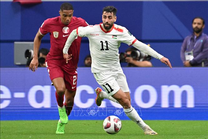 Tiền đạo Palestine Oday Dabbagh (số 11) đi bóng qua hậu vệ Qatar Pedro Miguel. Ảnh: AFP/TTXVN