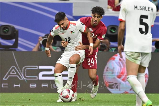 Pha tranh bóng giữa hậu vệ Qatar Jassem Gaber (số 24) và đối thủ Palestine Camilo Saldana (số 12). Ảnh: AFP/TTXVN