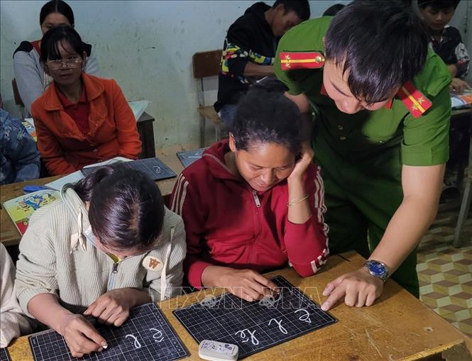 Trung uý Lê Tuấn Thành hướng dẫn học viên từng nét chữ. Ảnh: TTXVN phát