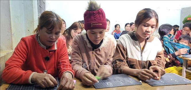 Học viên tập viết chữ tại lớp học tình thương. Ảnh: TTXVN phát