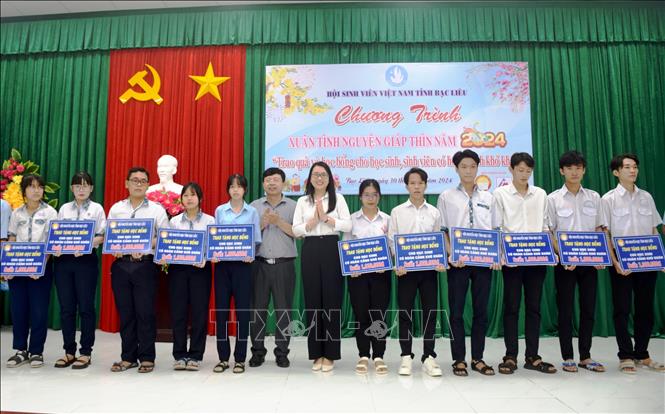 Ông Nguyễn Văn Nguyên - Phó Giám đốc Sở Giáo dục và Đào tạo tỉnh Bạc Liêu và Phó Bí thư Tỉnh đoàn, Chủ tịch Hội Sinh viên Việt Nam tỉnh Bạc Liêu Nguyễn Trang Anh Thư trao học bổng cho các học sinh, sinh viên có hoàn cảnh khó khăn. Ảnh: Chanh Đa-TTXVN