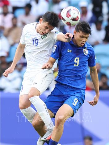 Pha tranh bóng bổng giữa tiền đạo Thái Lan Look Saa Mickelson (phải) với tiền vệ Azizbek Turgunboev của Uzbekistan. Ảnh: THX/TTXVN