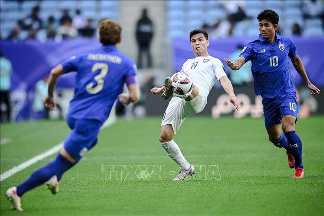 Tiền vệ Uzbekistan Azizbek Turgunboev (giữa) nỗ lực kiểm soát bóng trước các tuyển thủ Thái Lan. Ảnh: THX/TTXVN