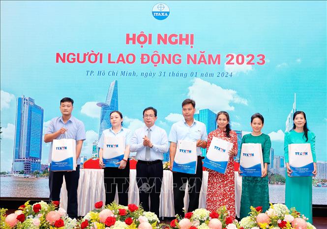 Ông Nguyễn Tuấn Hùng, Phó Tổng Giám đốc TTXVN trao quà của lãnh đạo TTXVN cho người lao động khó khăn của Công ty ITAXA. Ảnh: An Hiếu - TTXVN
