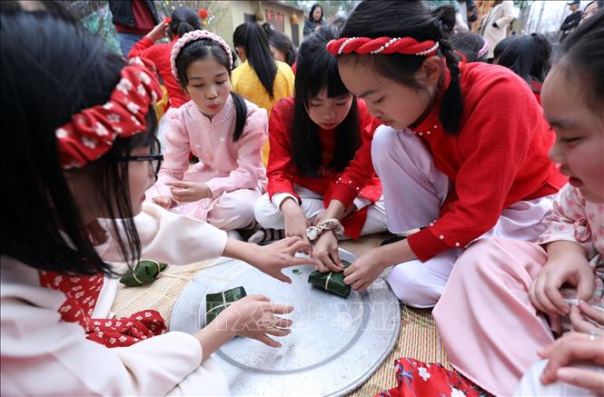 Học sinh Trường Tiểu học Chi Lăng (TP Lạng Sơn) trải nghiệm hoạt động gói bánh chưng tại Bảo tàng tỉnh Lạng Sơn. Ảnh: Anh Tuấn – TTXVN