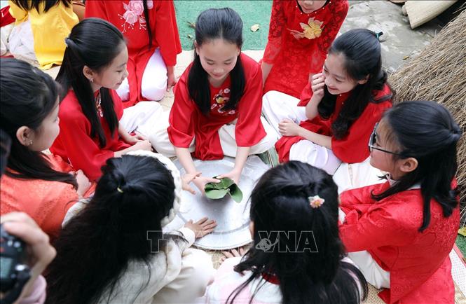 Học sinh Trường Tiểu học Chi Lăng (TP Lạng Sơn) trải nghiệm hoạt động gói bánh chưng tại Bảo tàng tỉnh Lạng Sơn. Ảnh: Anh Tuấn – TTXVN