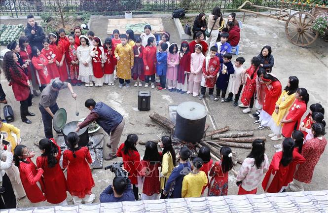 Học sinh Trường Tiểu học Chi Lăng (TP Lạng Sơn) trải nghiệm hoạt động vớt bánh chưng vừa được luộc chín. Ảnh: Anh Tuấn – TTXVN