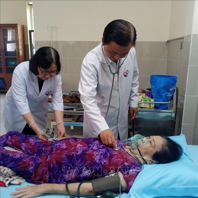 Tiến sỹ, bác sỹ, linh mục Phạm Vũ Thụy, Giám đốc chuyên môn Phòng khám, khám bệnh cho bệnh nhân. Ảnh: Minh Hưng – TTXVN
