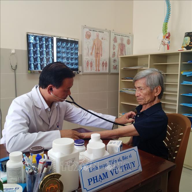 Tiến sỹ, bác sỹ, linh mục Phạm Vũ Thụy, Giám đốc chuyên môn Phòng khám, khám bệnh cho bệnh nhân. Ảnh: Minh Hưng – TTXVN