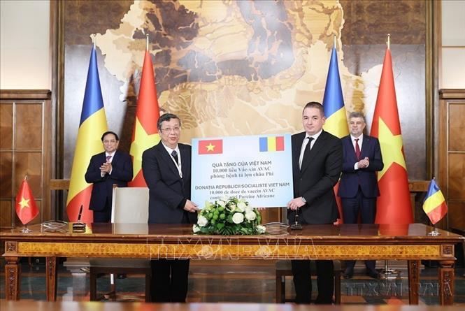 Thủ tướng Phạm Minh Chính và Thủ tướng Romania Ion-Marcel Ciolacu chứng kiến đại diện Việt Nam trao tặng 10.000 liều vaccine AVAC phòng bệnh tả lợn châu Phi cho Romania (Bucharest, 2024). Ảnh: Dương Giang-TTXVN