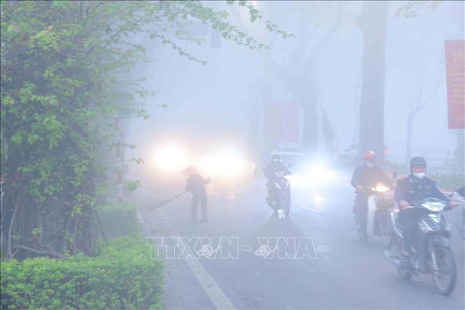 Các phương tiện di chuyển khó khăn trong lớp sương mù dày đặc trên phố Hoàng Diệu. Ảnh: An Đăng - TTXVN