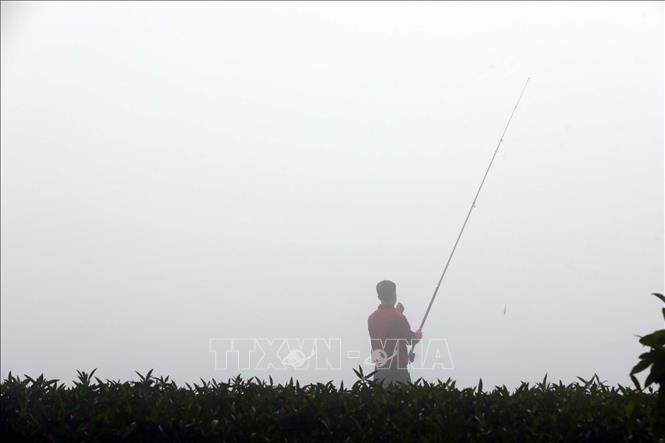 Một người dân câu cá trên hồ Thiền Quang. (Ảnh chụp 8h sáng 2/2). Ảnh: Huy Hùng - TTXVN