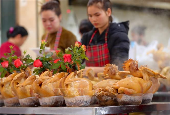 Gà luộc buộc cánh tiên, ngậm hoa được mua nhiều để cúng ông Công, ông Táo. Ảnh: Hoàng Hiếu - TTXVN 