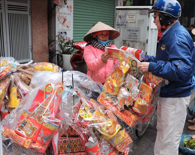 Đồ vàng mã, bộ 3 “mũ áo quan” là mặt hàng được tiêu thụ mạnh bởi đây là thứ không thể thiếu trong lễ cúng các Táo theo phong tục truyền thống của người Việt. Ảnh: Hoàng Hiếu - TTXVN 