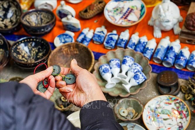 Tỉ mẩn lựa chọn những món đồ cũ trong chợ hoa truyền thống Hàng Lược cũng là một thú vui của người dân Thủ đô dịp cận Tết. Ảnh: Khánh Hoà - TTXVN