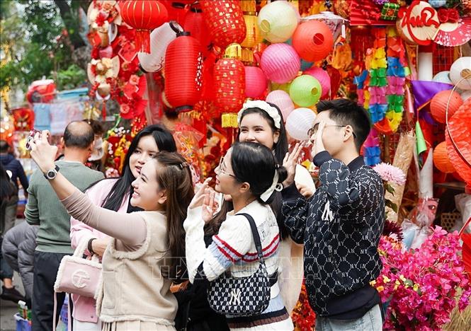 Chợ hoa Tết truyền thống Hàng Lược luôn thu hút rất đông các bạn trẻ đến du Xuân, lưu lại những khoảnh khắc đầu năm. Ảnh: Khánh Hoà - TTXVN